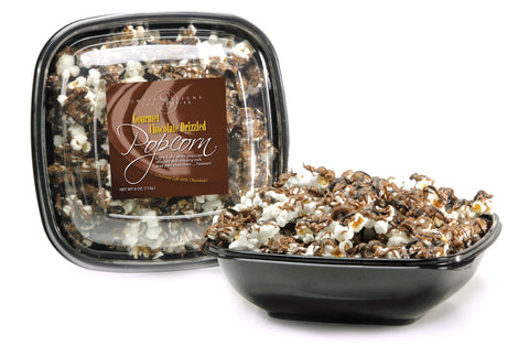Popcorn lightly drizzled with chocolate in a tub